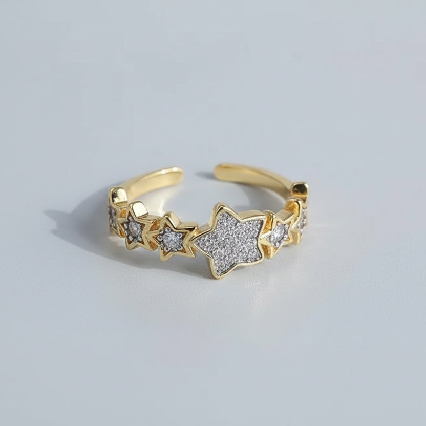 Gold ring with star designs on a white surface