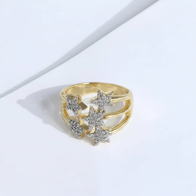 Gold ring with star-shaped gemstones on a light background