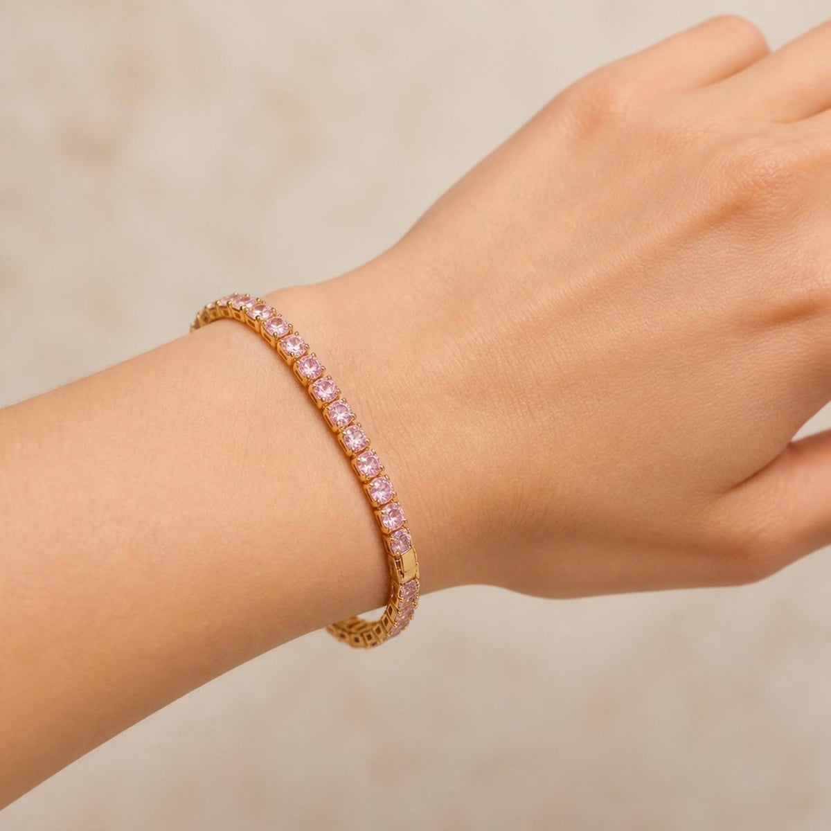 Pink tennis bracelet worn on a wrist