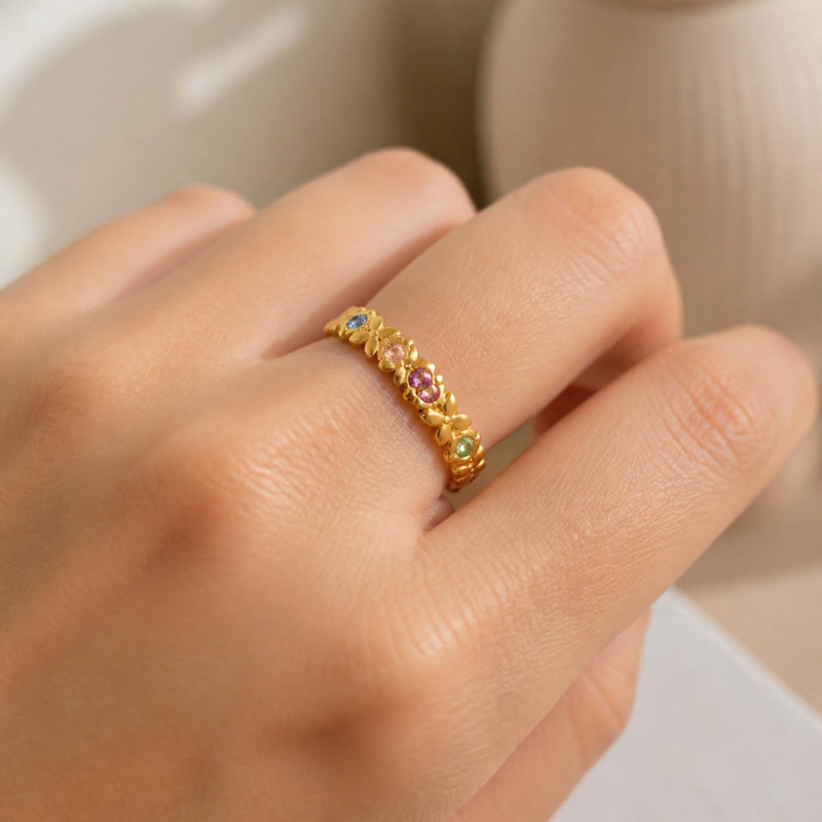 Molly Ring worn on finger, showing the colourful gemstones set along the band