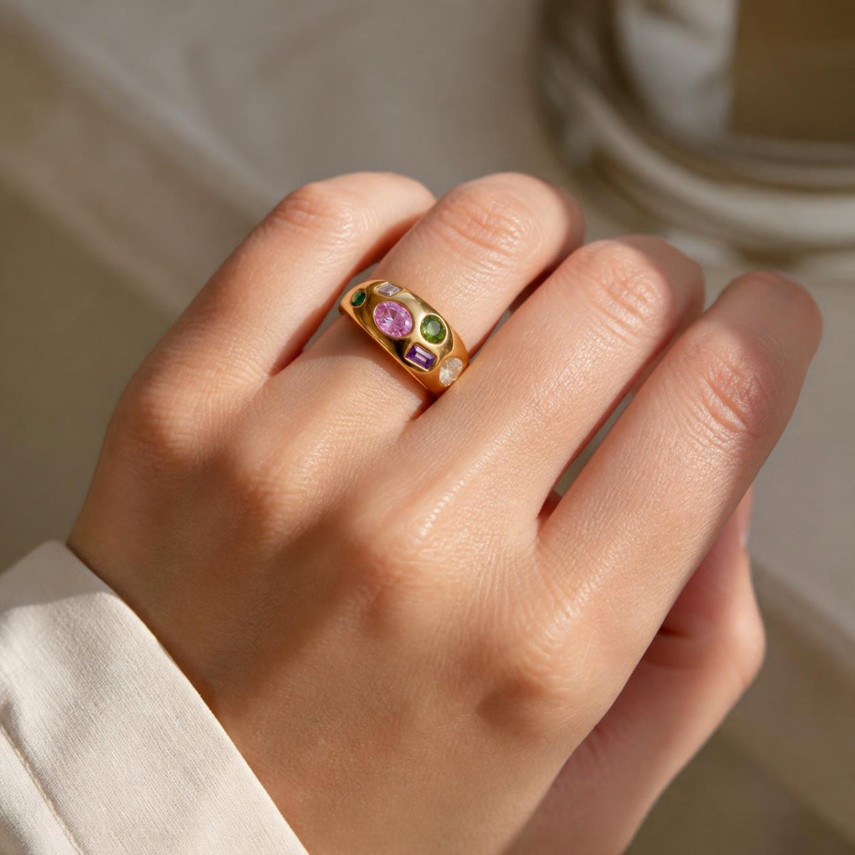 Gold ring with sparkling stones worn on a hand