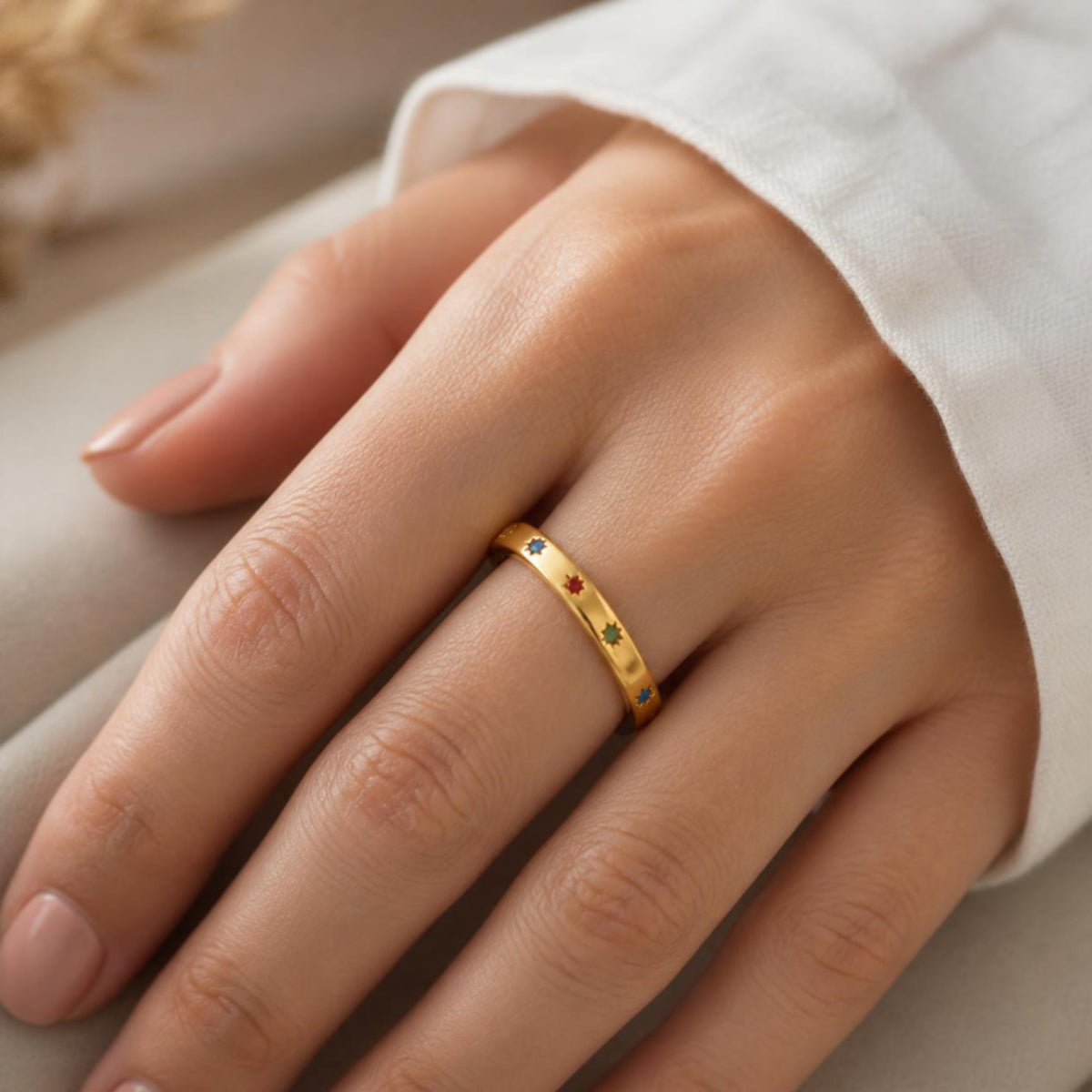 Curve Gem Ring worn on finger, showing the scattered colourful star gemstones around the band