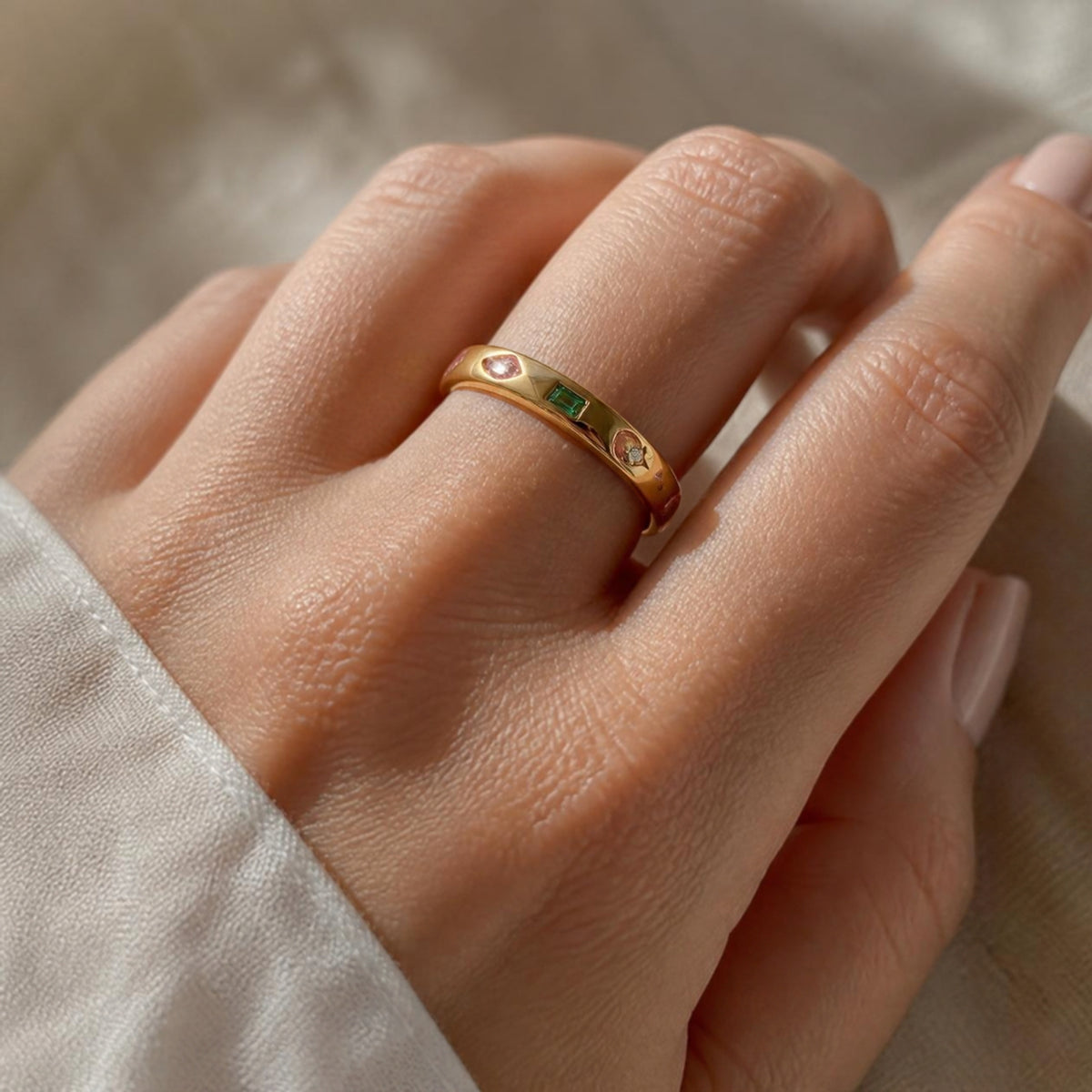 Popular Ring worn on finger, showing the assortment of colourful gemstones around the band