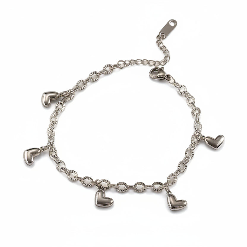 Silver bracelet with heart-shaped charms on a white surface