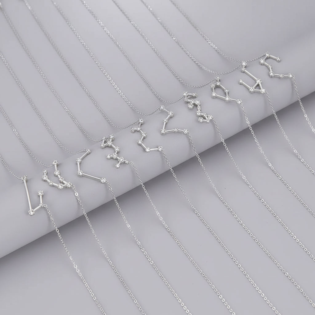 Silver constellation necklaces on a dark surface