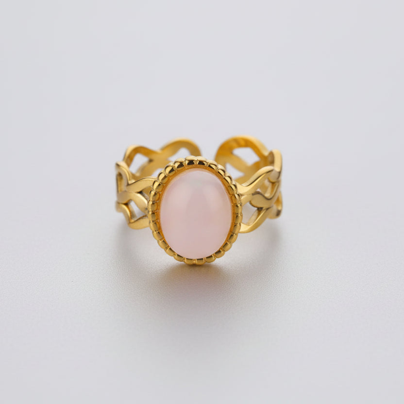 Gold ring with a pink stone, s on a white background