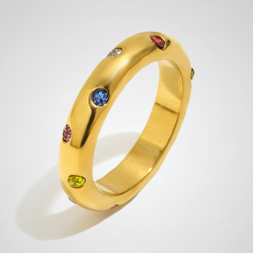 Gold ring with colorful gemstones on a white background