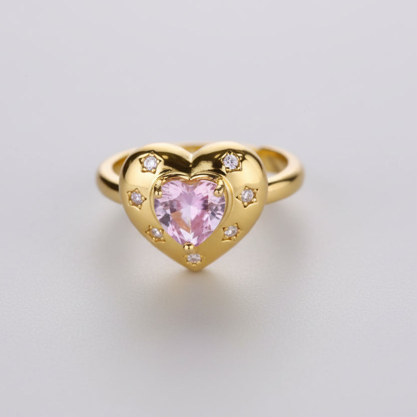 Gold heart-shaped ring with a pink gemstone on a white background