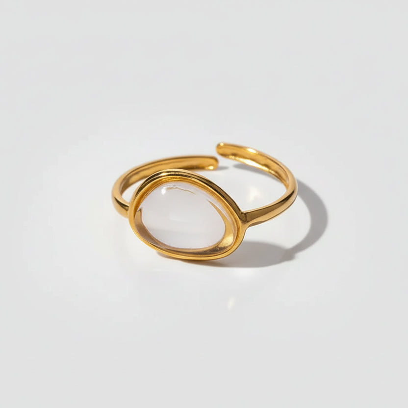 Gold ring with a white stone on a white background