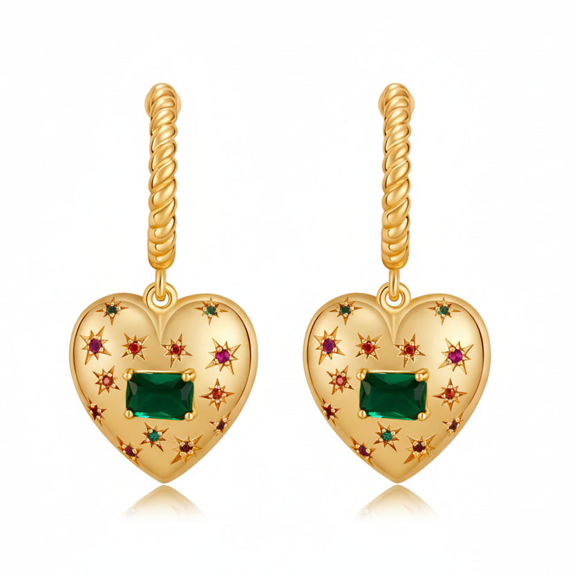 Gold heart-shaped earrings with green gemstones  on a white background