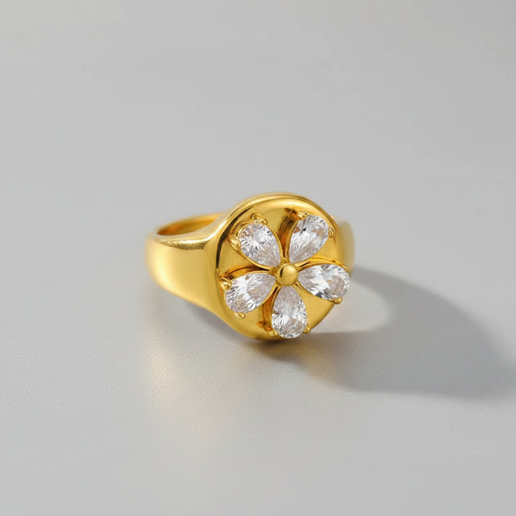 Gold ring with floral design on a pink background, showing measurements and material details.