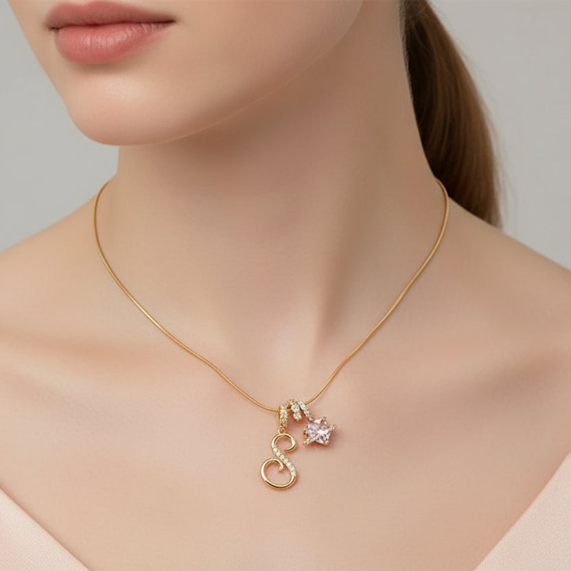 Woman wearing a gold necklace with heart-shaped pendants on a neutral background