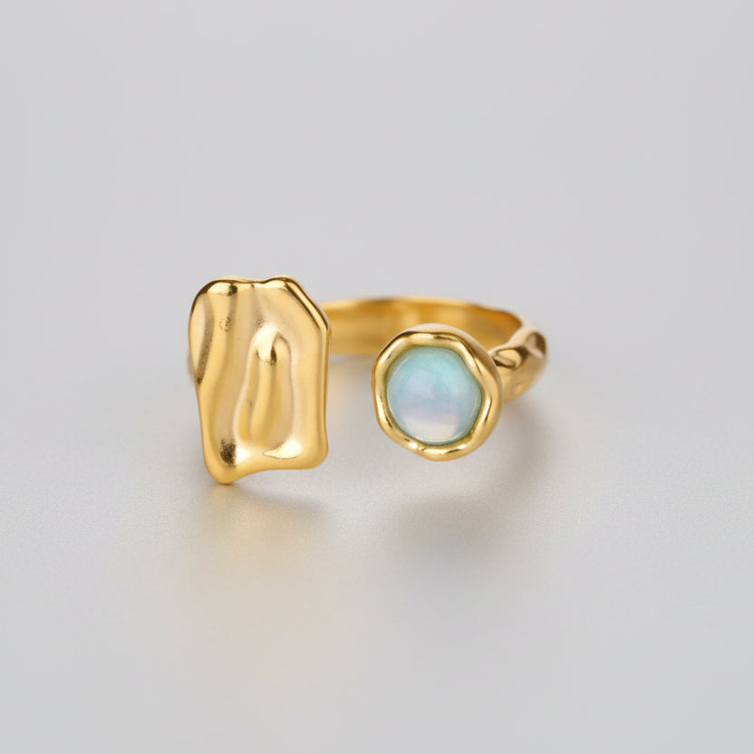 Gold ring with a green stone on a white background