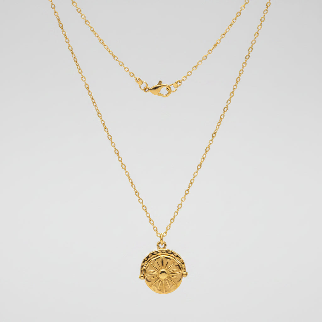 Gold necklace with a round pendant on a white background
